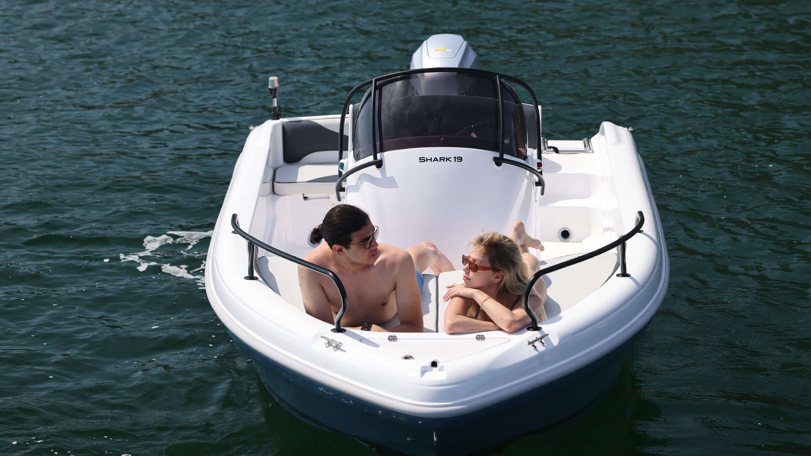 Barco a motor en mar con pareja disfrutando del sol en Nautica Marina Alta.