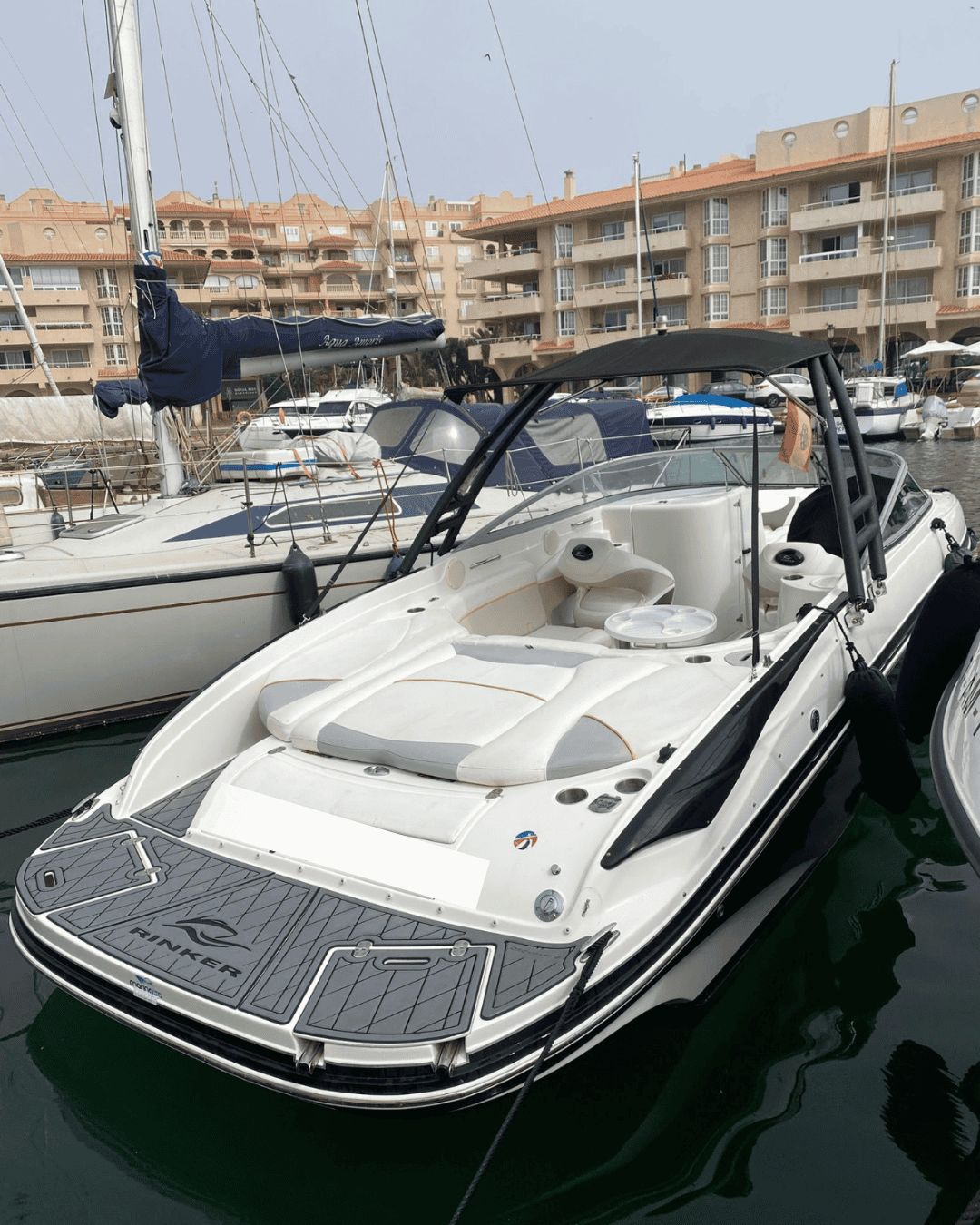 Bote a motor en puerto con marinas y apartamentos de lujo en la Marina Alta.